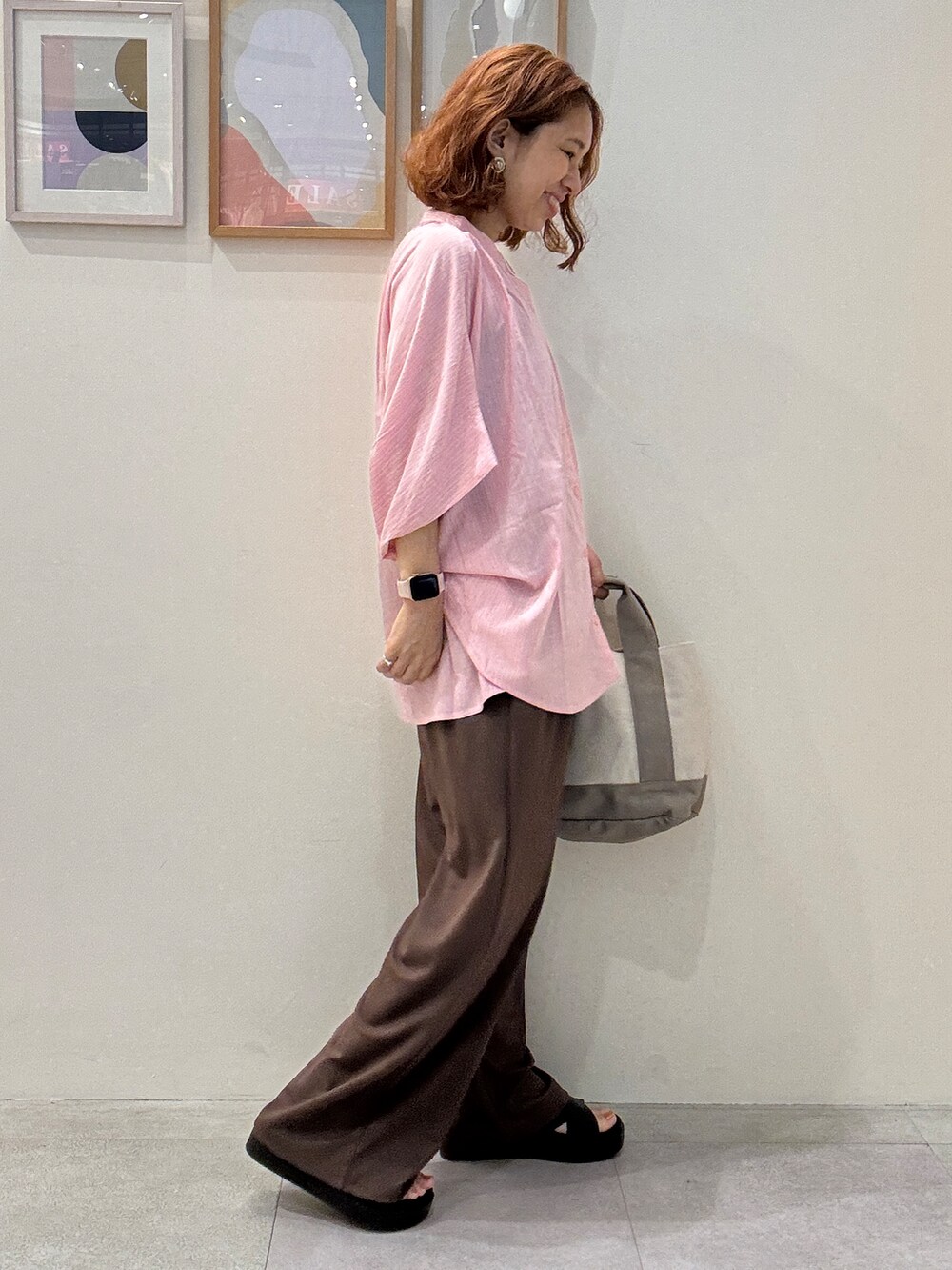 ピンク系のシャツ/ブラウス、ブラウン系のその他パンツ、グレー系のトートバッグを着用したレディースの夏コーディネートの2枚目の写真