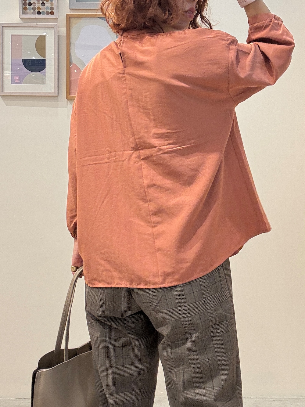 オレンジ系のシャツ/ブラウス、ブラウン系のその他パンツ、ベージュ系のトートバッグを着用したレディースの秋コーディネートの6枚目の写真