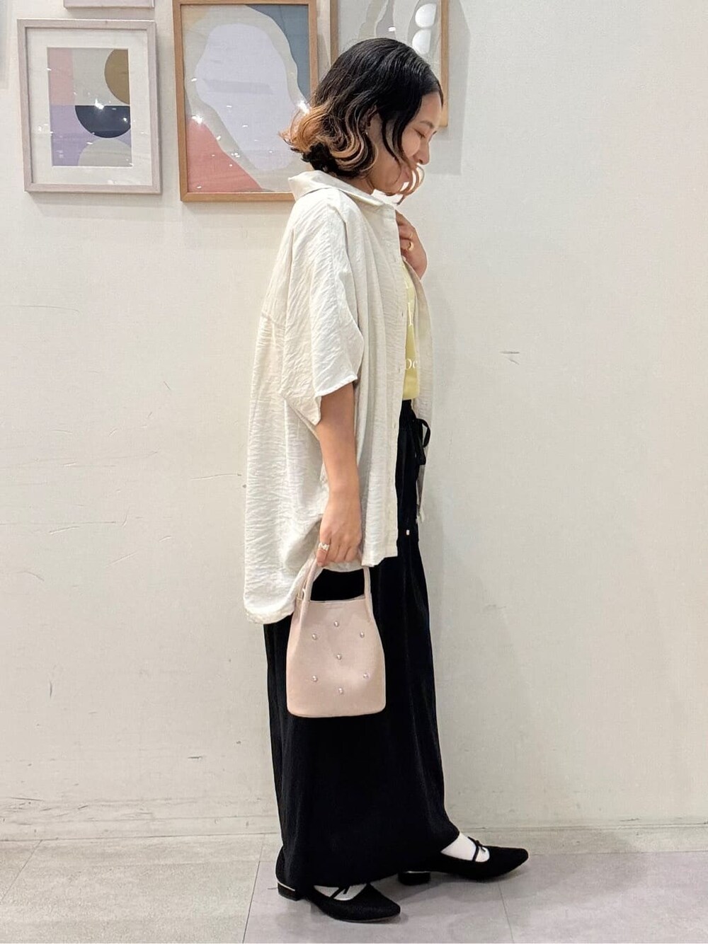 ベージュ系のシャツ/ブラウス、イエロー系のTシャツ/カットソー、ブルー系のスカートを着用したレディースの秋コーディネートの2枚目の写真