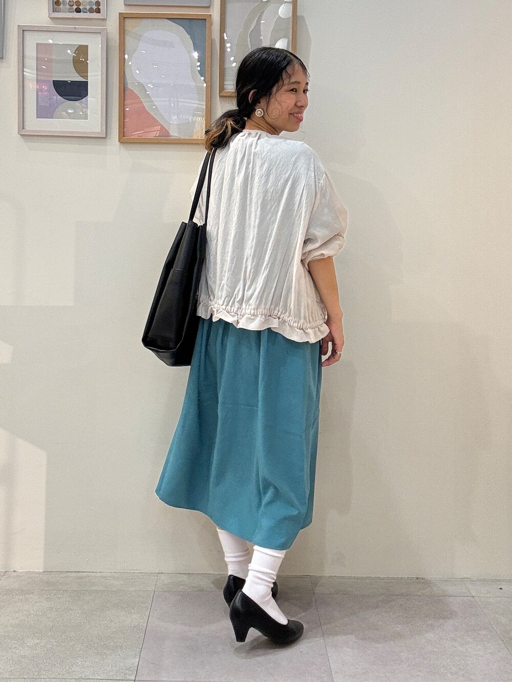 ベージュ系のブルゾン、ブルー系のワンピース、ブラック系のトートバッグを着用したレディースの夏コーディネートの3枚目の写真