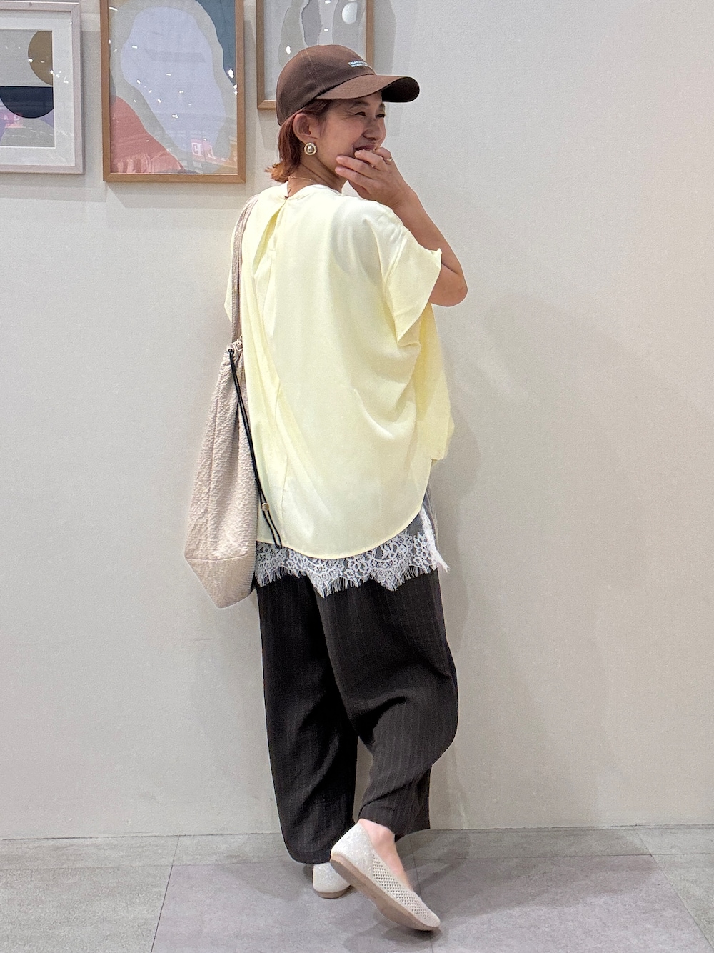 イエロー系のTシャツ/カットソー、ホワイト系のタンクトップ、ベージュ系のトートバッグを着用したレディースの夏コーディネートの3枚目の写真