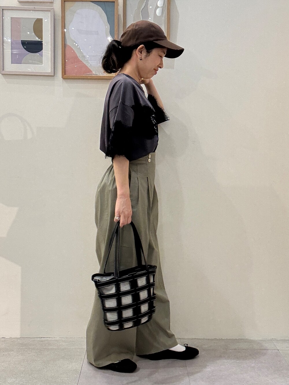 ブラック系のその他シューズ、ブラック系のトートバッグ、グレー系のTシャツ/カットソーを着用したレディースの春コーディネートの2枚目の写真