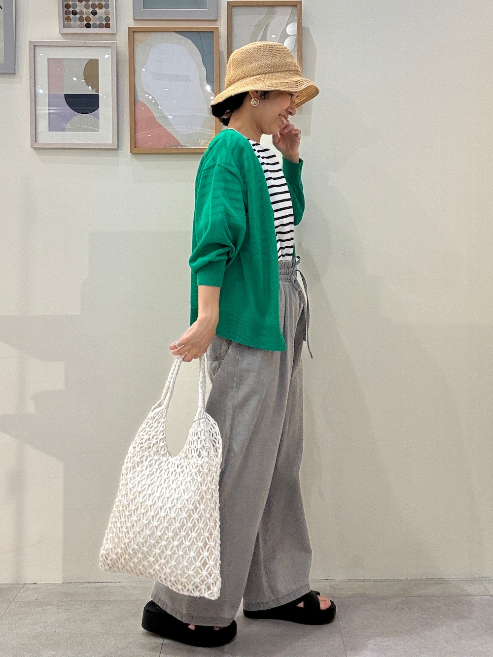 グリーン系のカーディガン/ボレロ、ホワイト系のTシャツ/カットソー、グレー系のデニムパンツを着用したレディースの春コーディネートの2枚目の写真