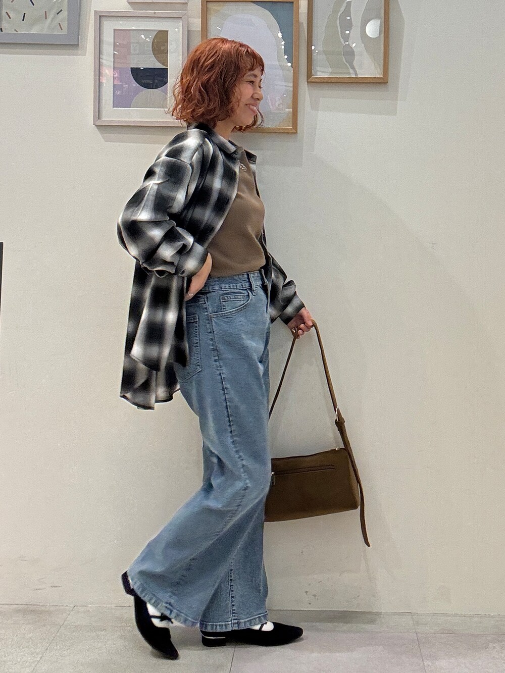 グレー系のシャツ/ブラウス、イエロー系のTシャツ/カットソー、ブルー系のデニムパンツを着用したレディースの秋コーディネートの2枚目の写真