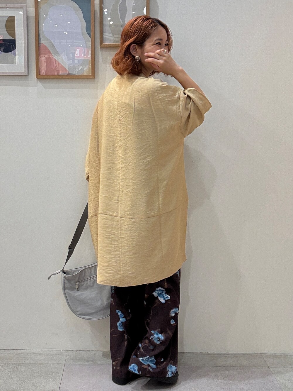 イエロー系のワンピース、ブラウン系のその他パンツ、グレー系のショルダーバッグを着用したレディースの夏コーディネートの3枚目の写真