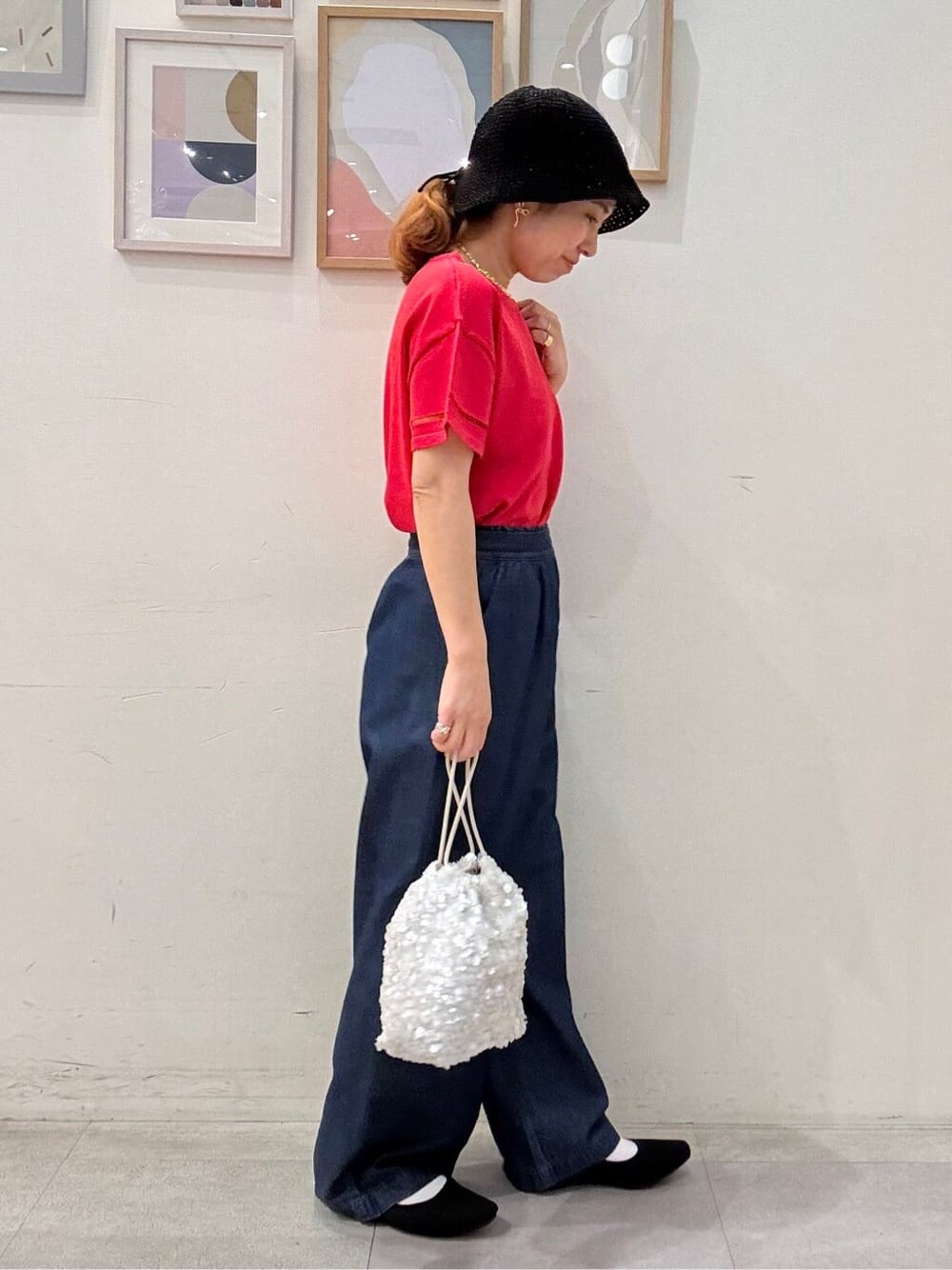 ピンク系のニット/セーター、ブルー系のその他パンツ、ホワイト系のショルダーバッグを着用したレディースの夏コーディネートの2枚目の写真
