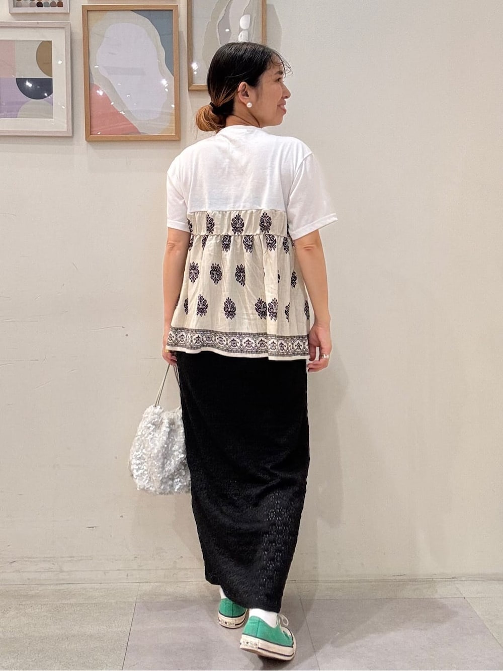 ベージュ系のTシャツ/カットソー、ブラック系のスカート、ホワイト系のショルダーバッグを着用したレディースの夏コーディネートの3枚目の写真