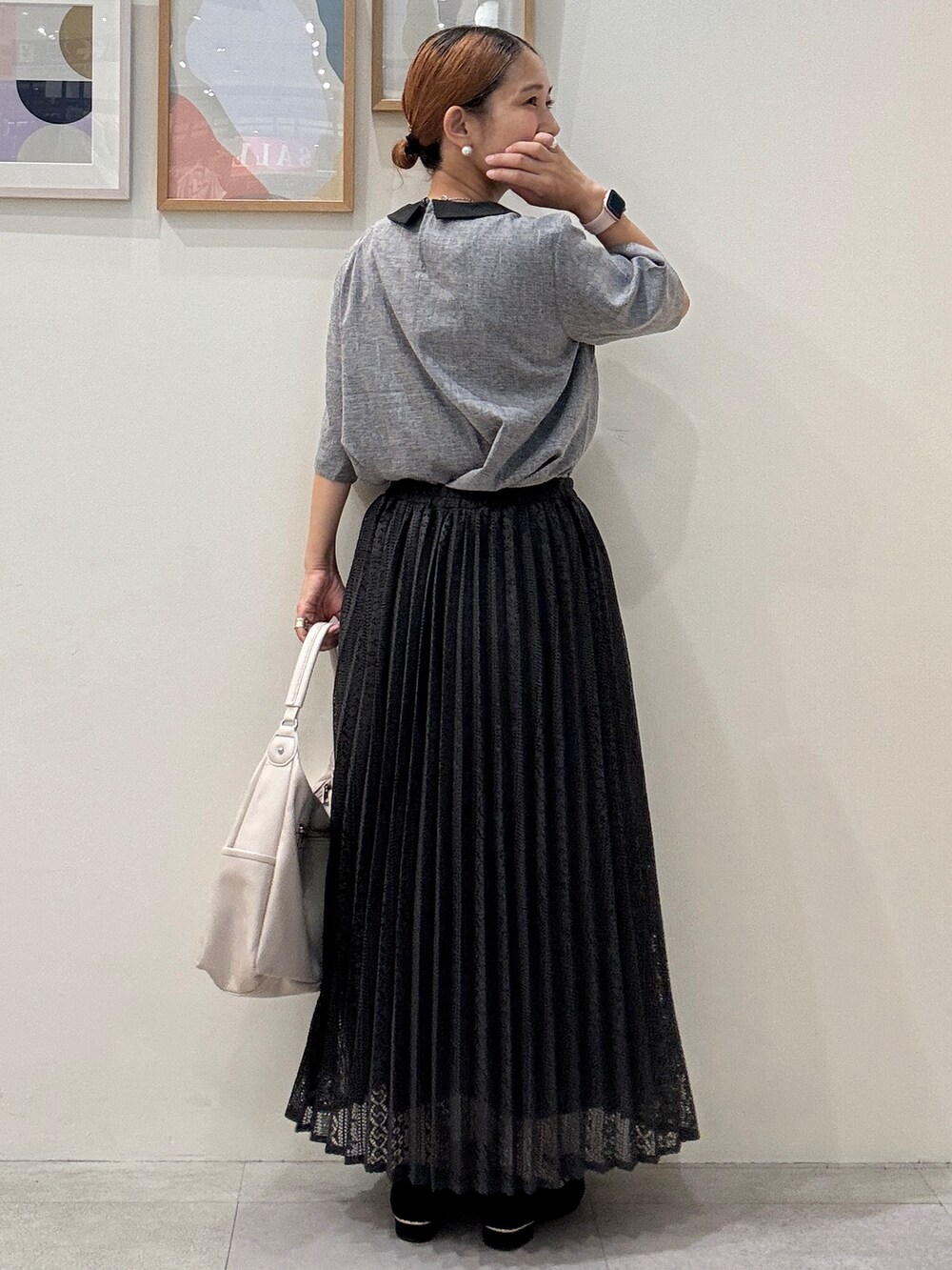グレー系のシャツ/ブラウス、ブラック系のスカート、ホワイト系のショルダーバッグを着用したレディースの夏コーディネートの3枚目の写真