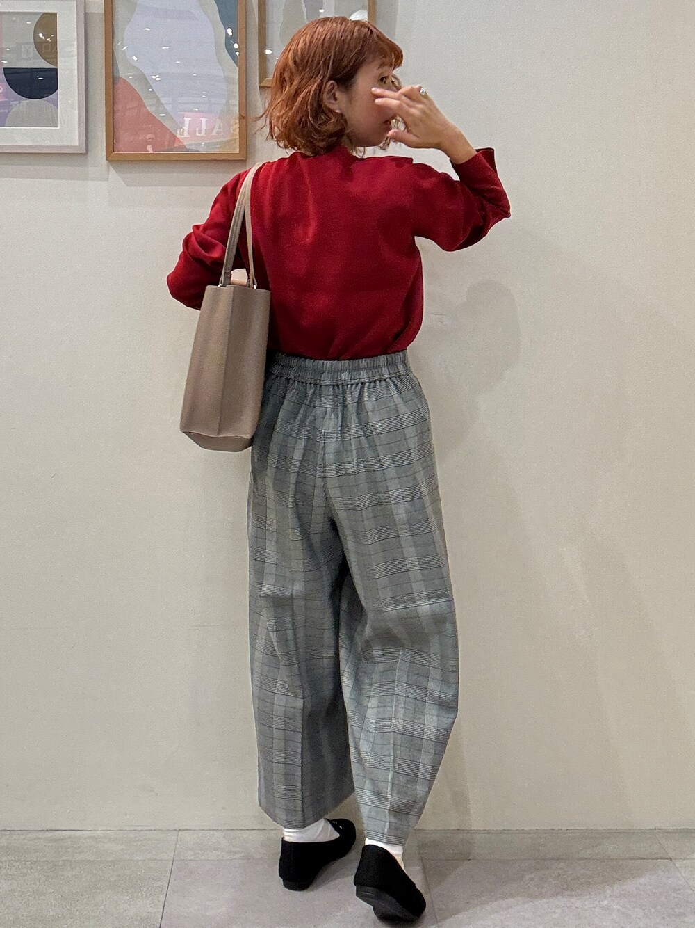 レッド系のニット/セーター、グレー系のその他パンツ、ブラック系のその他シューズを着用したレディースの秋コーディネートの3枚目の写真