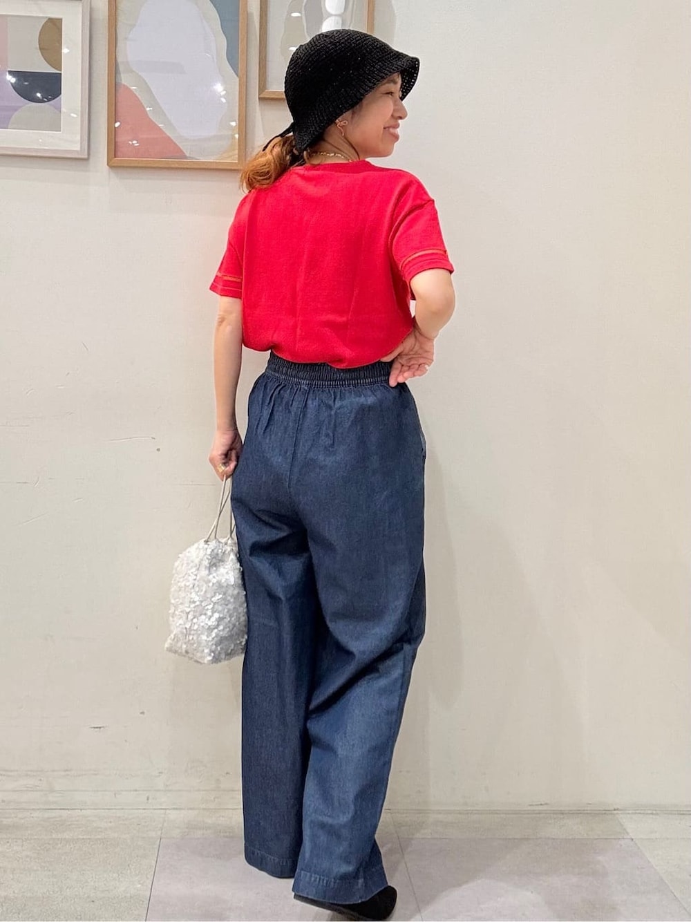 ピンク系のニット/セーター、ブルー系のその他パンツ、ホワイト系のショルダーバッグを着用したレディースの夏コーディネートの3枚目の写真