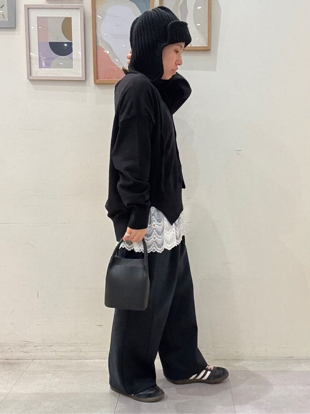 ブラック系のニット/セーター、ホワイト系のTシャツ/カットソー、ブラック系のその他パンツを着用したレディースの秋コーディネートの2枚目の写真