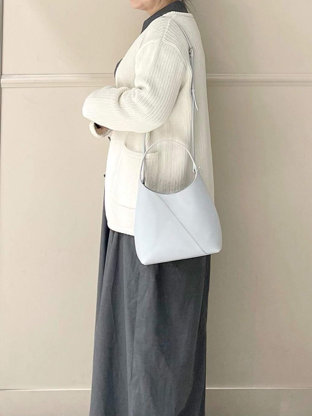 ブルー系のトートバッグ、ホワイト系のカーディガン/ボレロを着用したレディースの春コーディネートの3枚目の写真