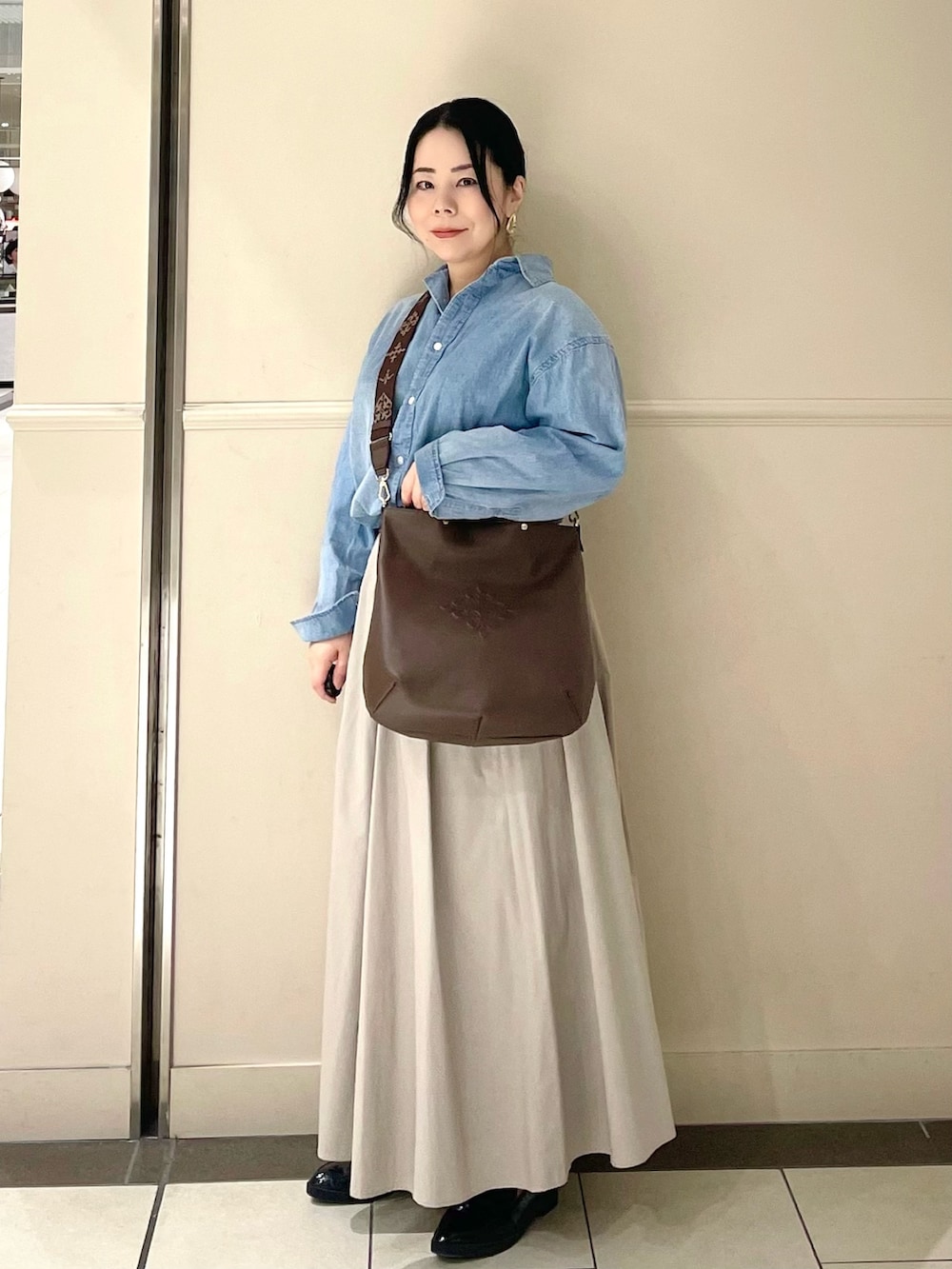 ブラウン系のトートバッグを着用したレディースの春コーディネートの2枚目の写真