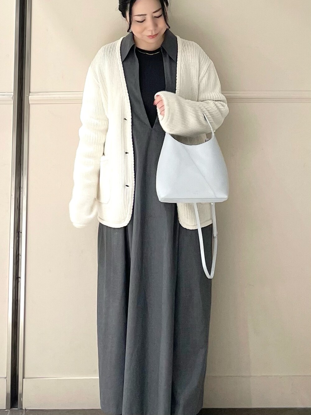 ブルー系のトートバッグ、ホワイト系のカーディガン/ボレロを着用したレディースの春コーディネートの2枚目の写真