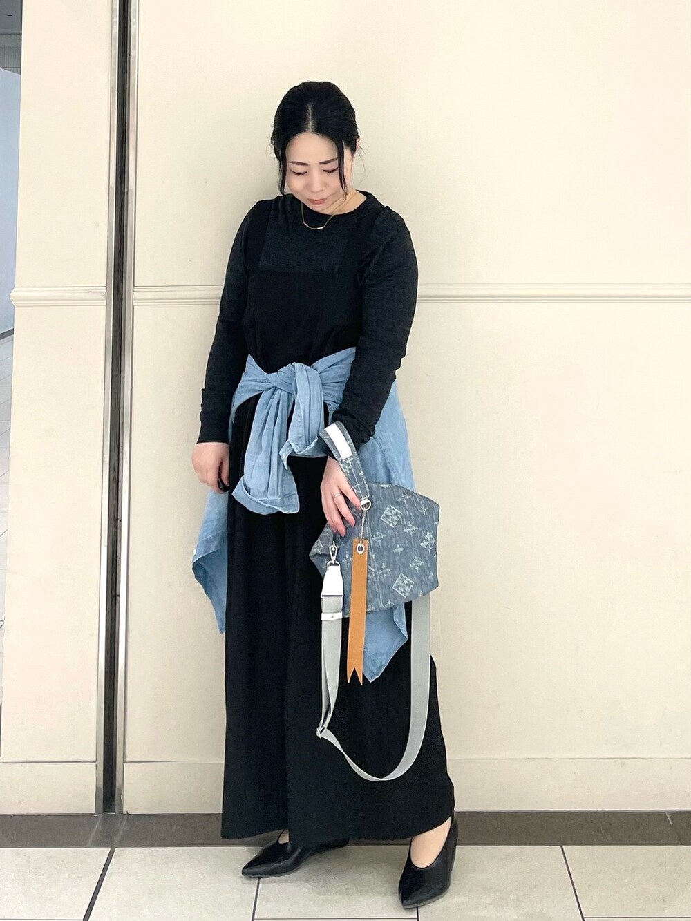 ブルー系のトートバッグを着用したレディースの春コーディネートの2枚目の写真