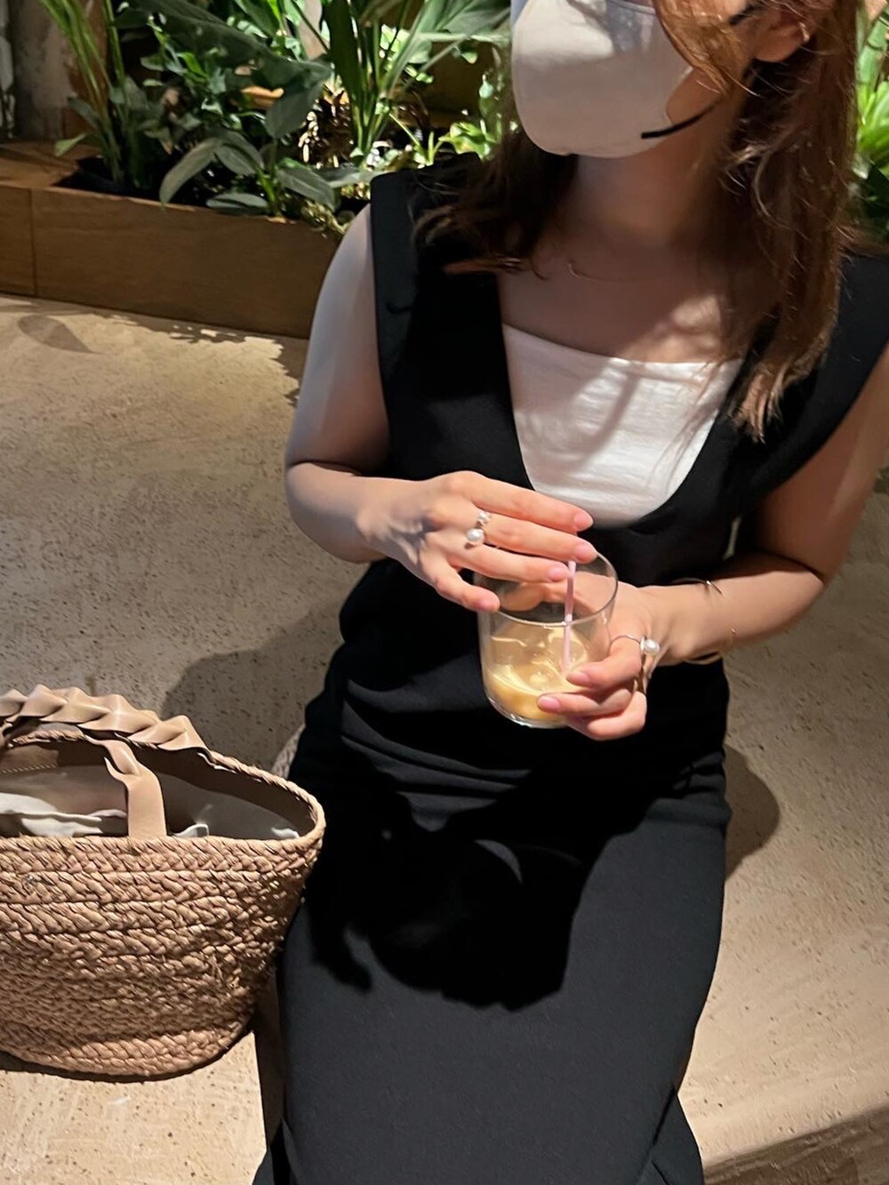 ブラック系のワンピース、ベージュ系のかごバッグ、ベージュ系のサンダルを着用したレディースの夏コーディネートの5枚目の写真