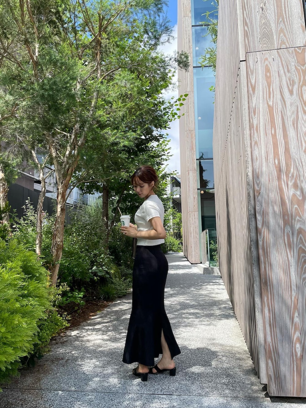 ホワイト系のTシャツ/カットソー、ベージュ系のトートバッグ、ブラック系のサンダルを着用したレディースの夏コーディネートの3枚目の写真