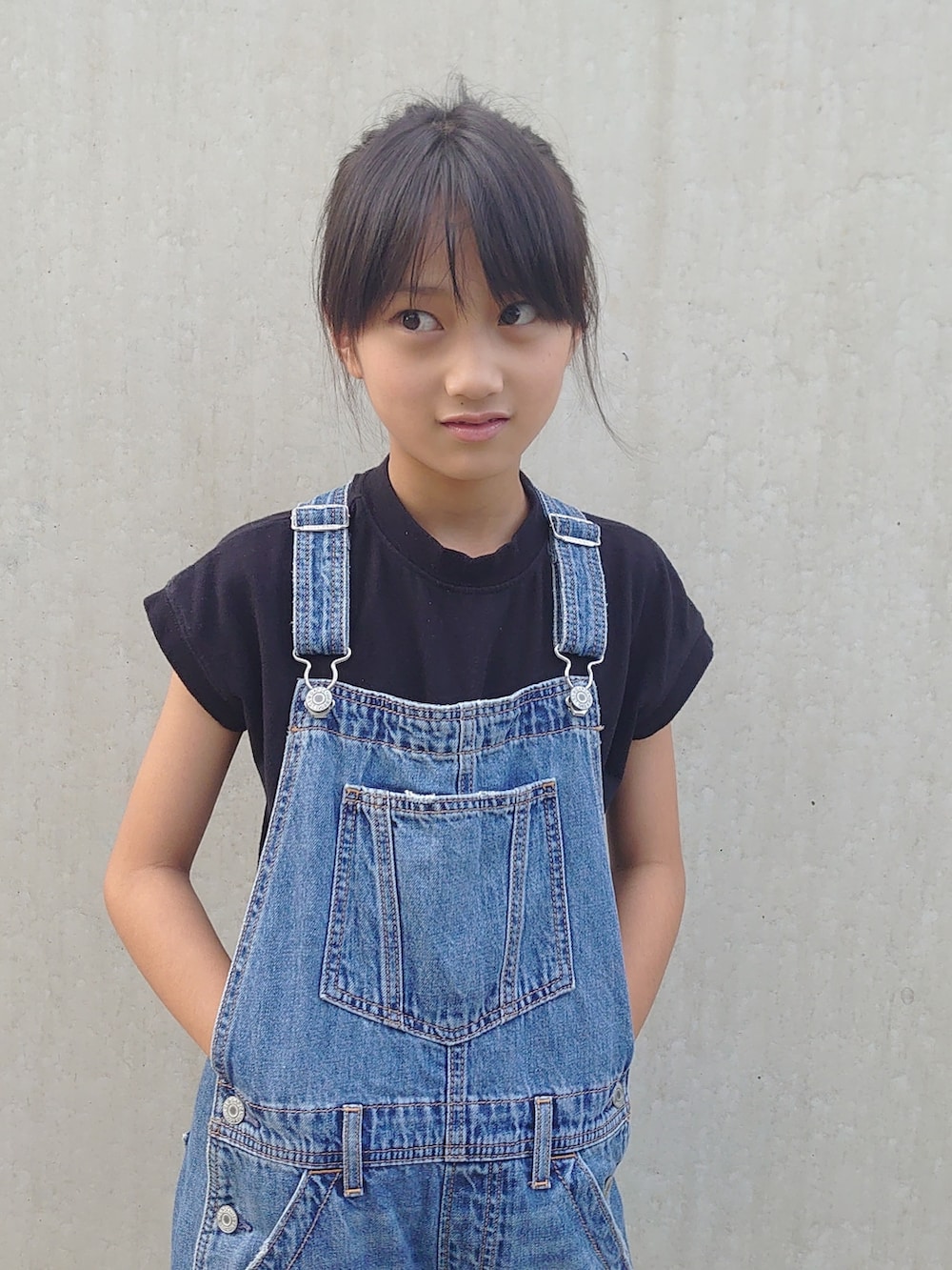 ブルー系のサロペット/オーバーオール、ホワイト系のシューズ、ブラック系のTシャツ/カットソーを着用したキッズの秋コーディネートの2枚目の写真