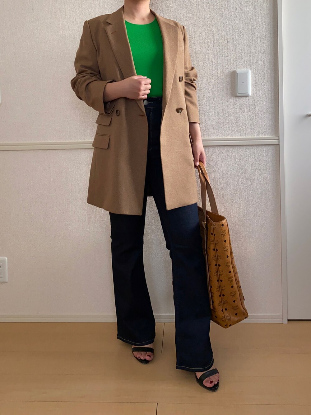 グリーン系のタンクトップ、ブルー系のデニムパンツ、ブラウン系のバッグを着用したレディースの春コーディネートの2枚目の写真