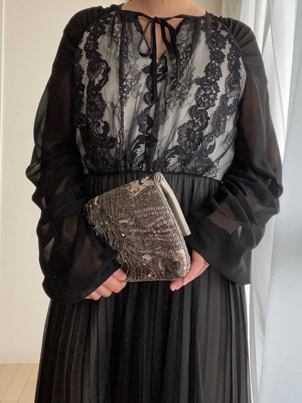 パープル系のパンプス、ブラック系のワンピースを着用したレディースの夏コーディネートの2枚目の写真