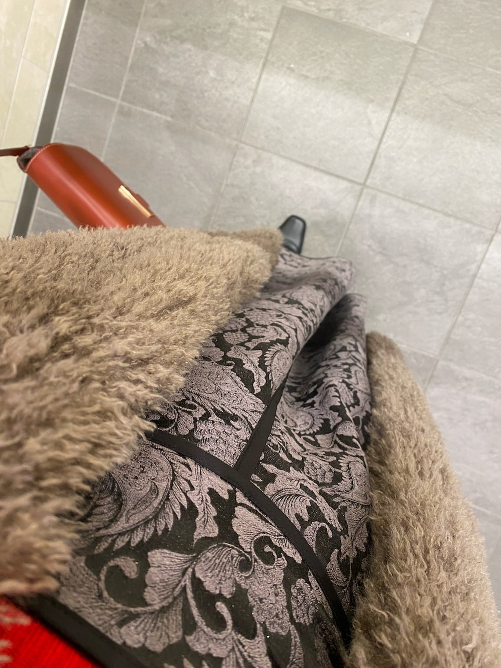 グレー系のスカート、ブラック系のブーツ、レッド系のニット/セーターを着用したレディースの冬コーディネートの2枚目の写真