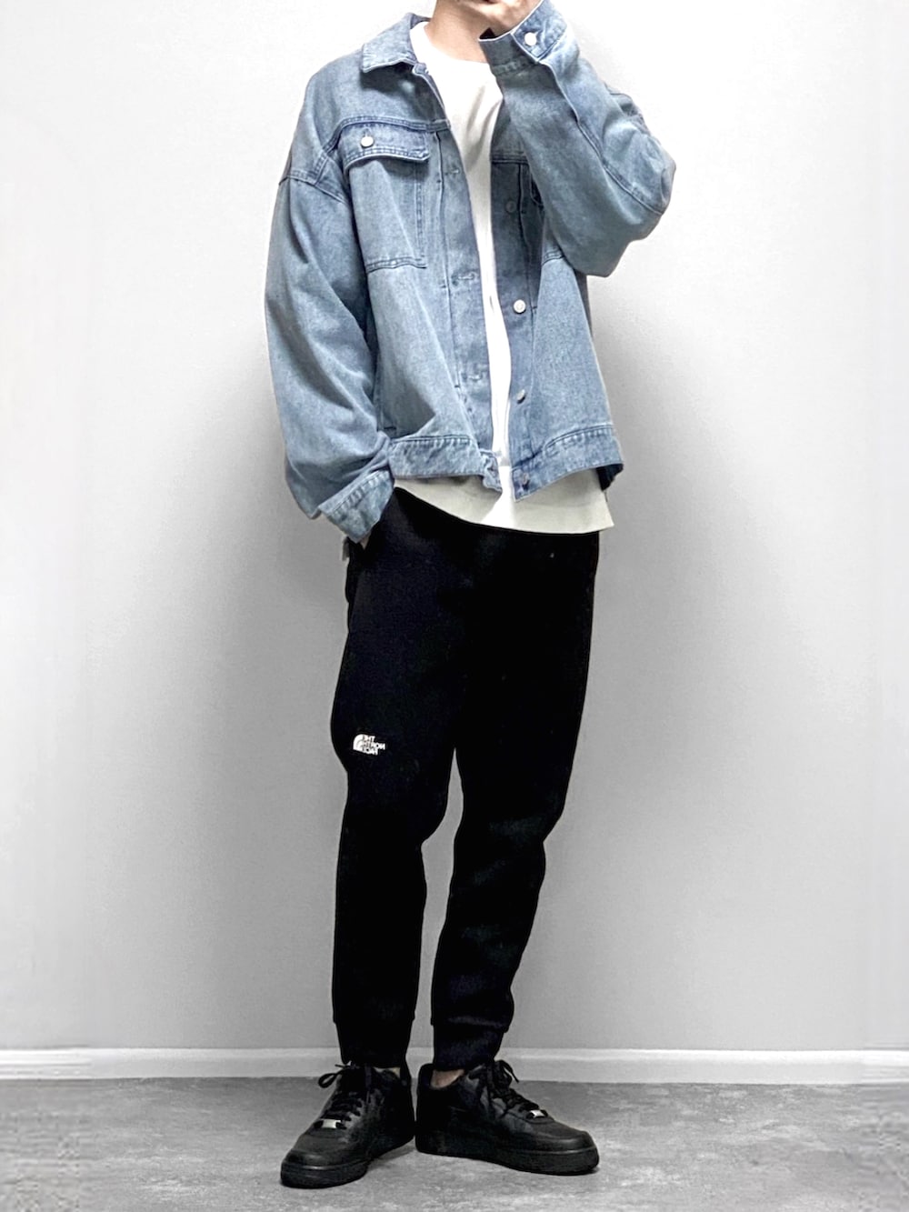 ブラック系のナイロンジャケット、ブラック系のその他パンツ、ブラック系のスニーカーを着用したメンズの春コーディネートの2枚目の写真