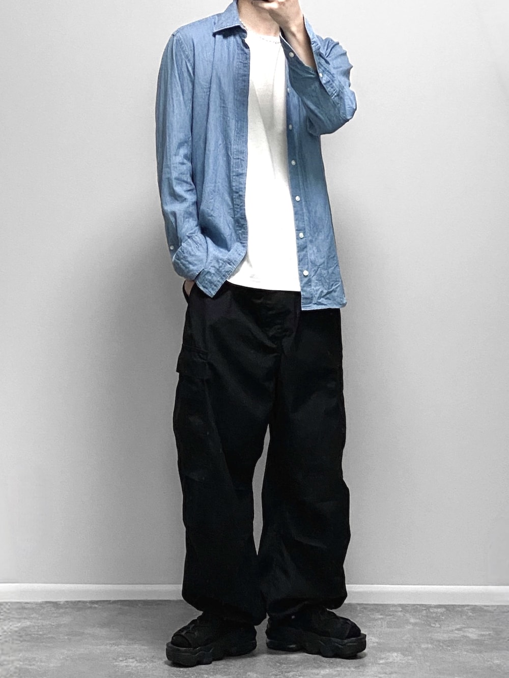 ブラック系のマウンテンパーカー、ホワイト系のタンクトップ、ブラック系のスラックスを着用したメンズの春コーディネートの2枚目の写真