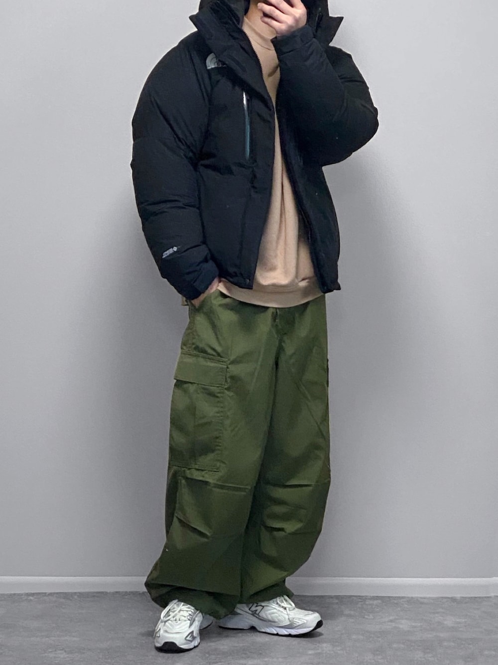 ブラック系のジャケット/アウター、ホワイト系のパーカー、グリーン系のカーゴパンツを着用したメンズの冬コーディネートの2枚目の写真