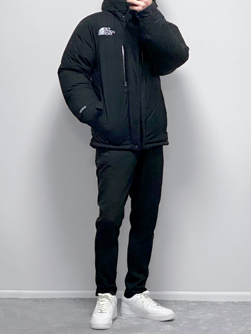 ブラック系のその他アウター、ブラック系のスウェット、ホワイト系のパンツを着用したメンズの冬コーディネートの2枚目の写真