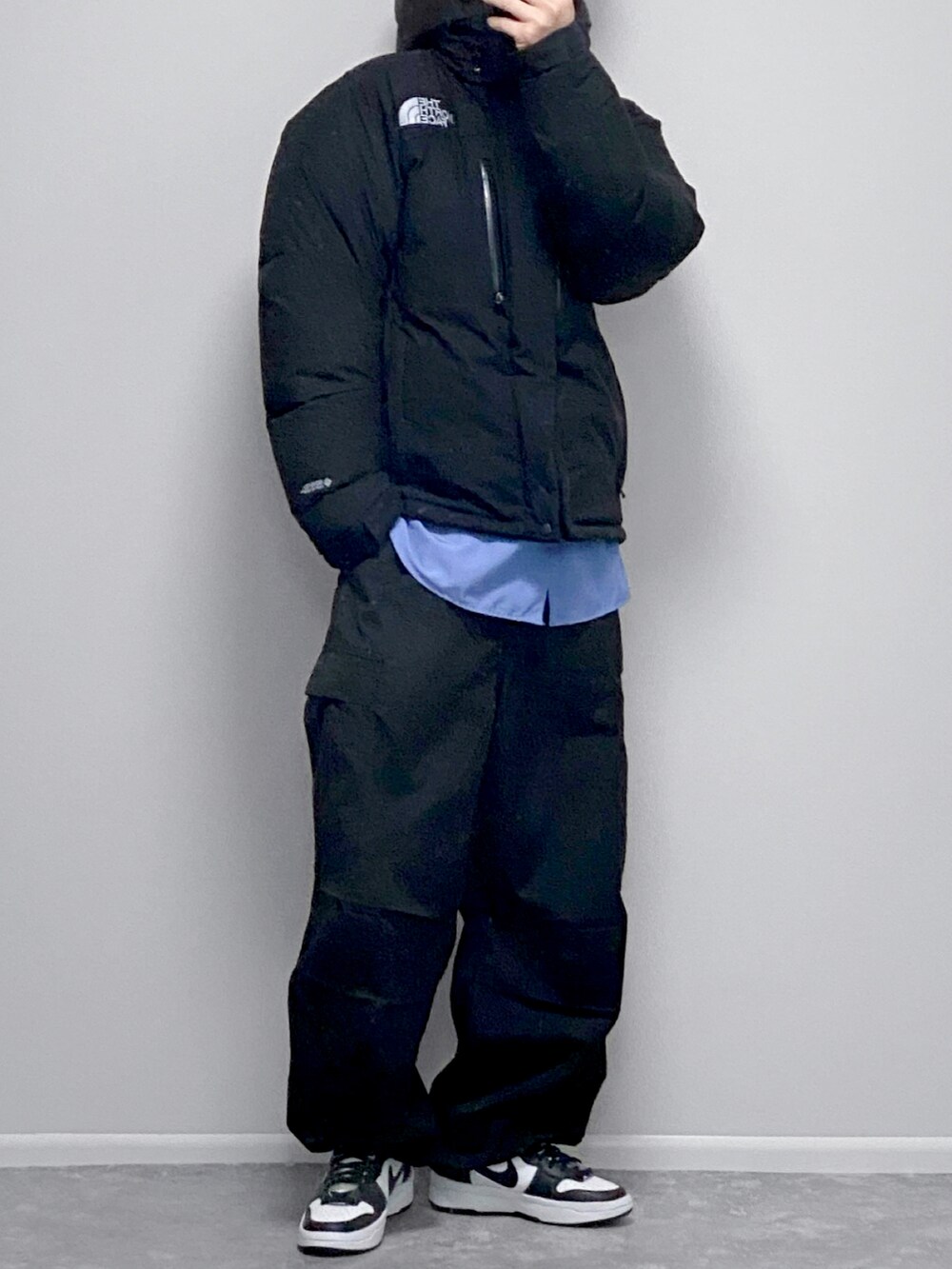 ブラック系のダウンジャケット/コート、ホワイト系のスウェットパンツ、ホワイト系のスニーカーを着用したメンズの春コーディネートの2枚目の写真