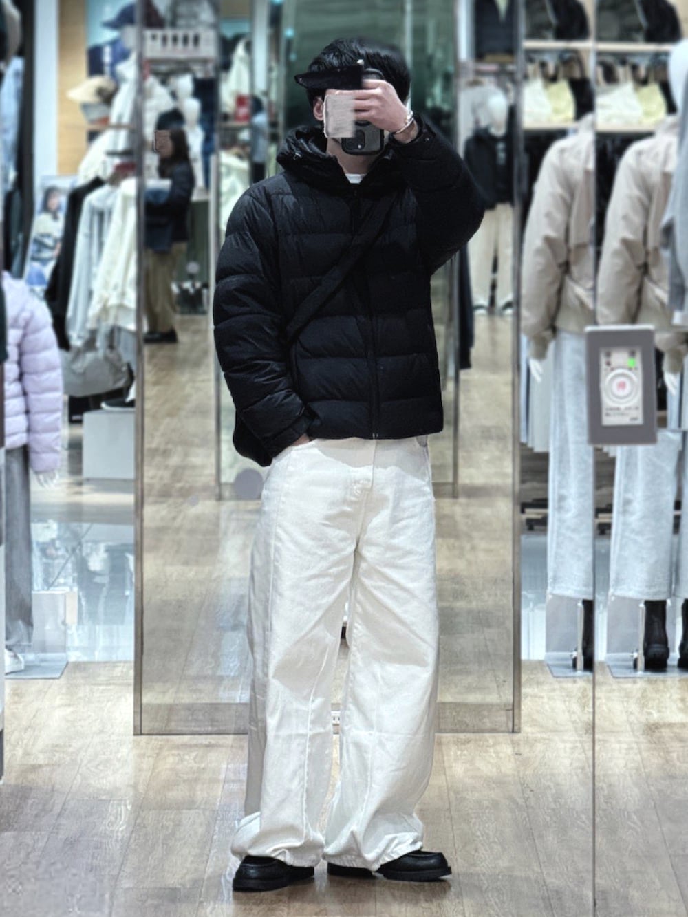 ブラック系のショルダーバッグ、ブラック系のダウンジャケット/コート、ブルー系のデニムパンツを着用したメンズの冬コーディネートの2枚目の写真