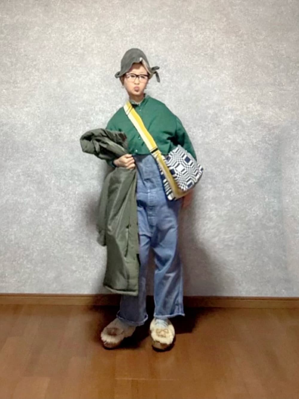 ベージュ系のその他シューズ、ブルー系のオールインワン・サロペット、グリーン系のジャケット/アウターを着用したレディースの冬コーディネートの2枚目の写真