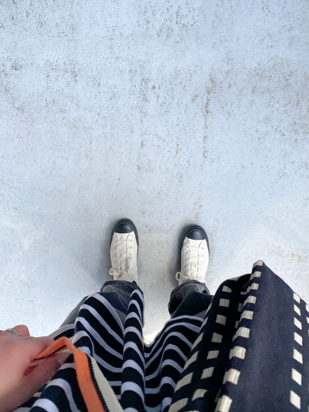 ホワイト系のシューズ、ブラック系のパンツ、ブラック系のバッグを着用したレディースの春コーディネートの2枚目の写真