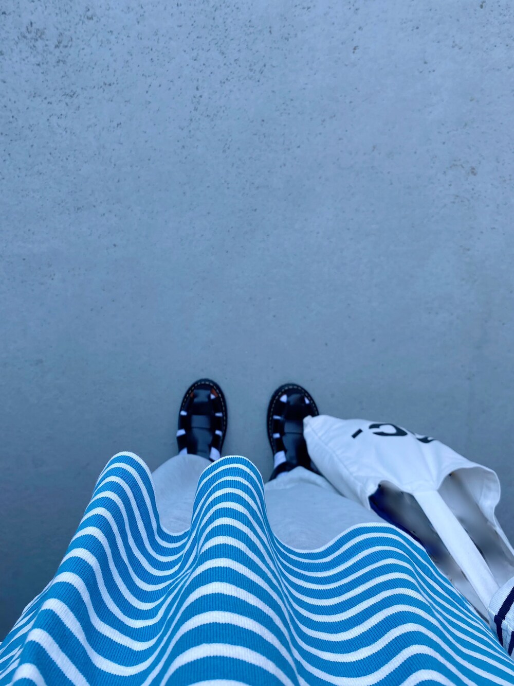 グレー系のパンツ、ブルー系のTシャツ/カットソー、ホワイト系のトップスを着用したレディースの春コーディネートの2枚目の写真