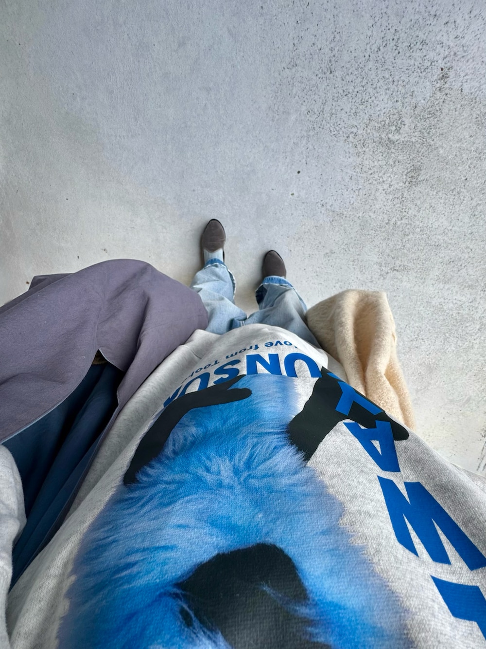 グレー系のスリッポン、ブルー系のデニムパンツ、ブルー系のバッグを着用したレディースの冬コーディネートの2枚目の写真