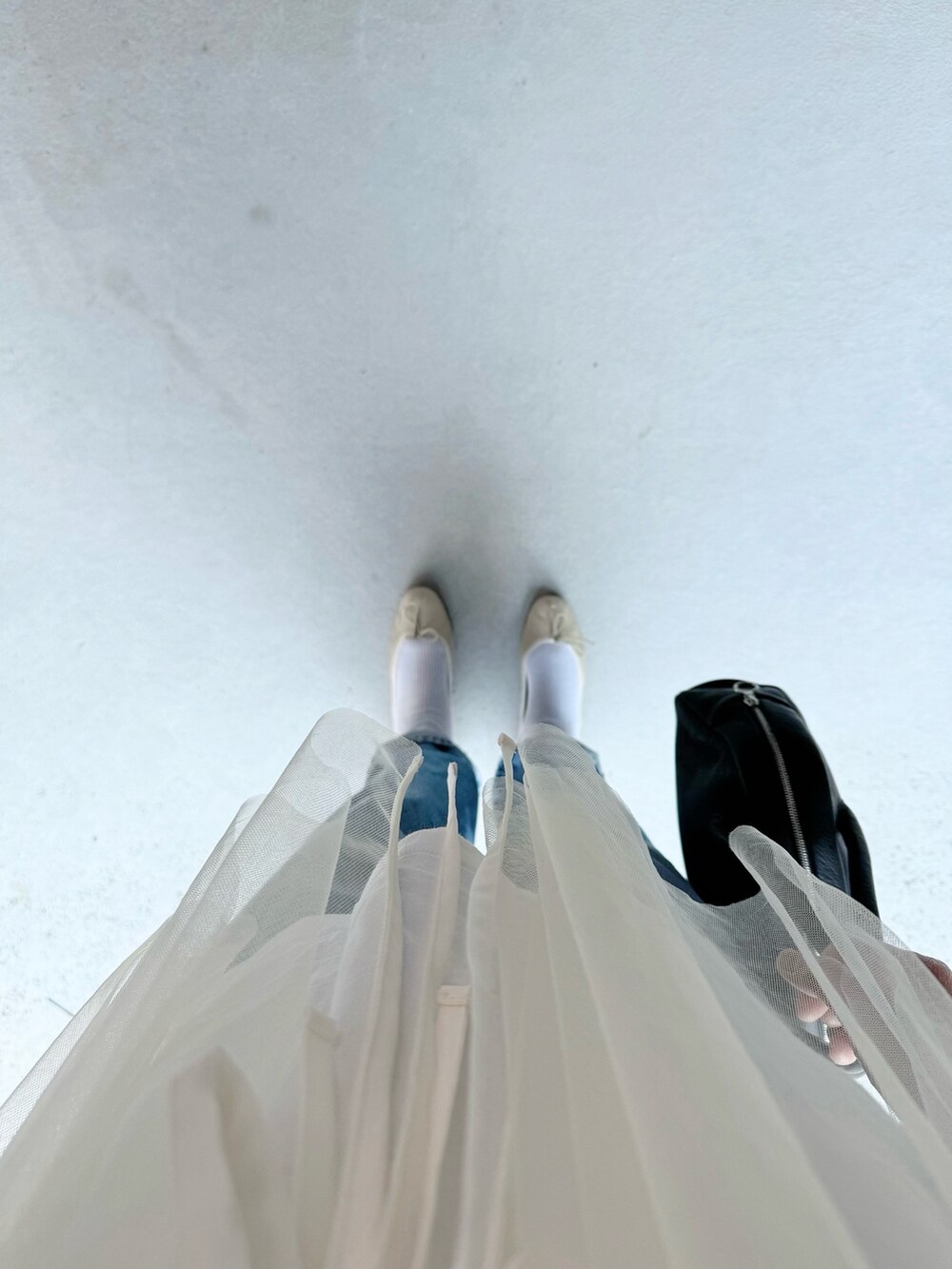 ベージュ系のバレエシューズ、ブルー系のパンツ、ブラック系のボストンバッグを着用したレディースの夏コーディネートの2枚目の写真