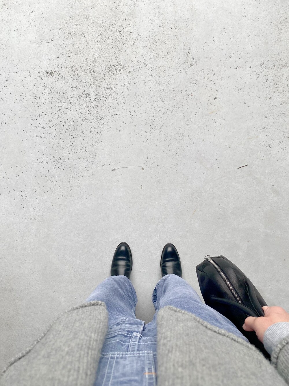 ブラック系のブーツ、ブルー系のオールインワン・サロペット、ブラック系のボストンバッグを着用したレディースの冬コーディネートの2枚目の写真