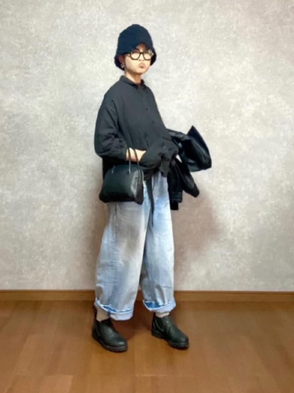 ブラック系のブーツ、ブルー系のデニムパンツ、ブラック系のジャケット/アウターを着用したレディースの冬コーディネートの2枚目の写真