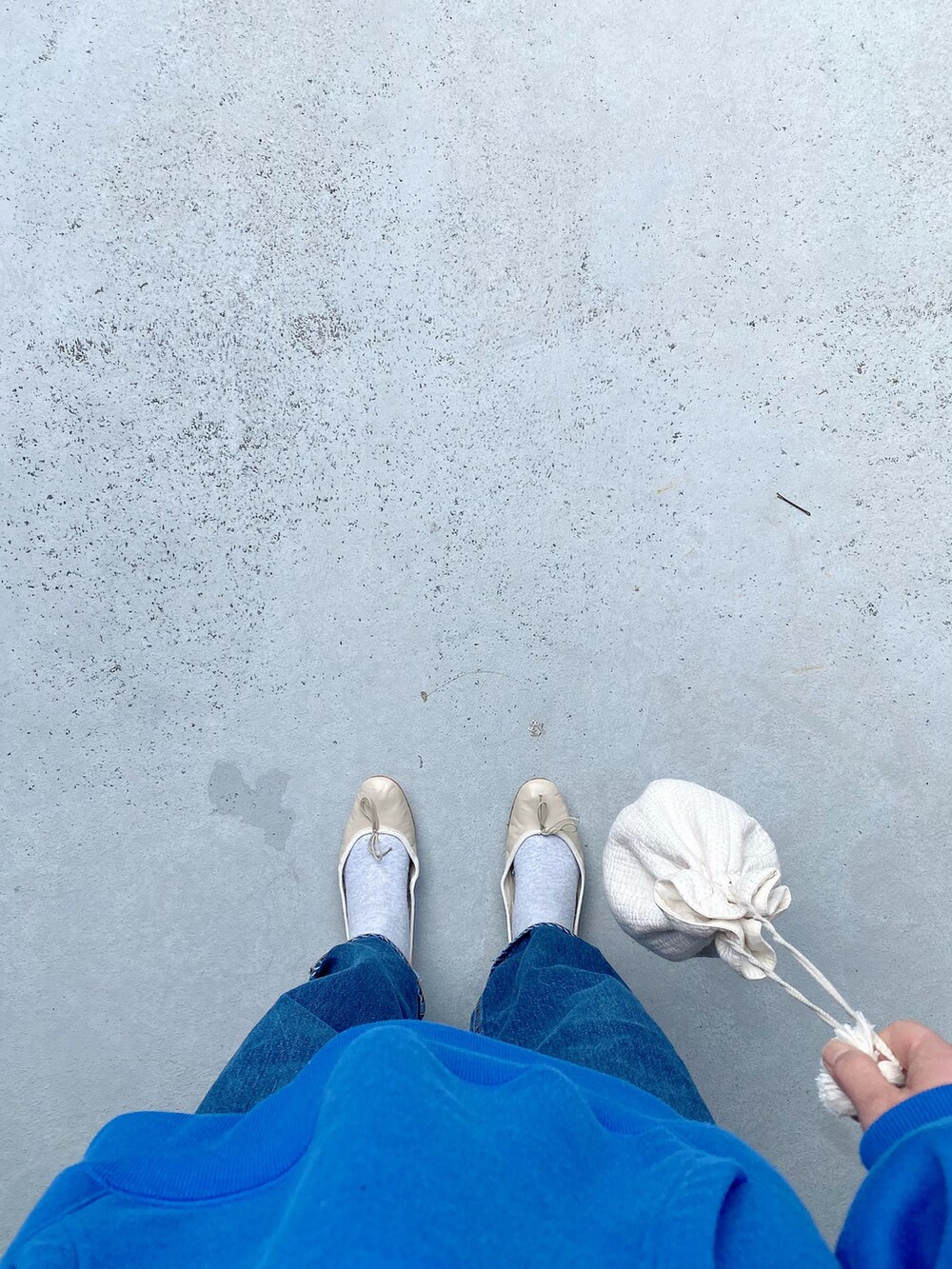 ベージュ系のバレエシューズ、ブルー系のパンツ、ブルー系のトップスを着用したレディースの春コーディネートの2枚目の写真