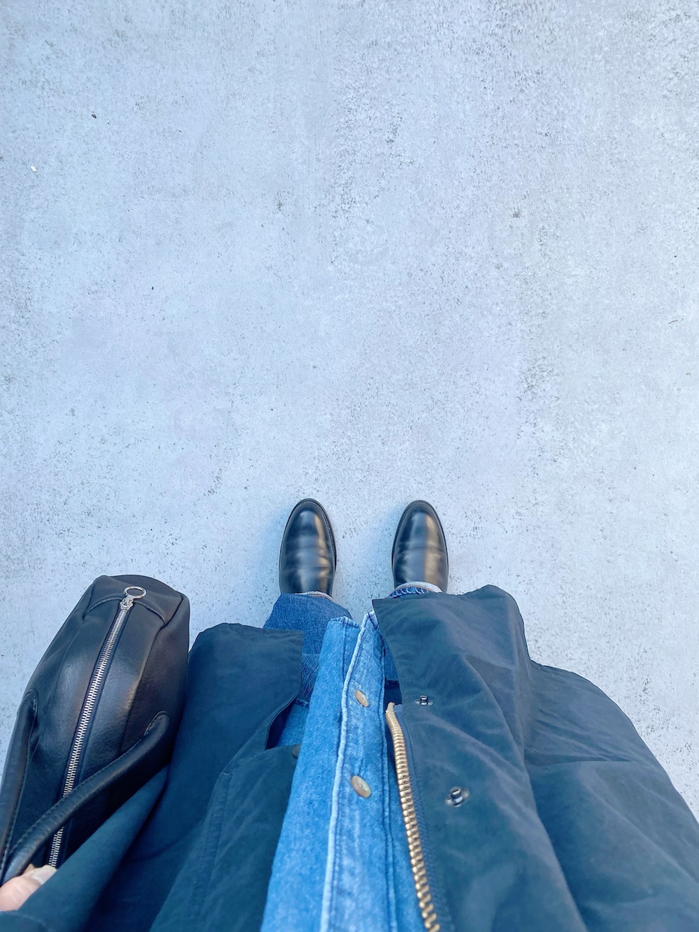 ブラック系のブーツ、ブルー系のパンツ、ブラック系のボストンバッグを着用したレディースの冬コーディネートの2枚目の写真