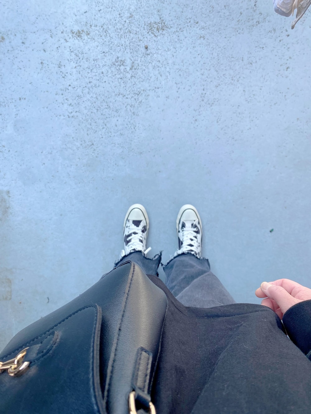 ホワイト系のスニーカー、ブラック系のパンツ、ブラック系のバッグを着用したレディースの春コーディネートの3枚目の写真