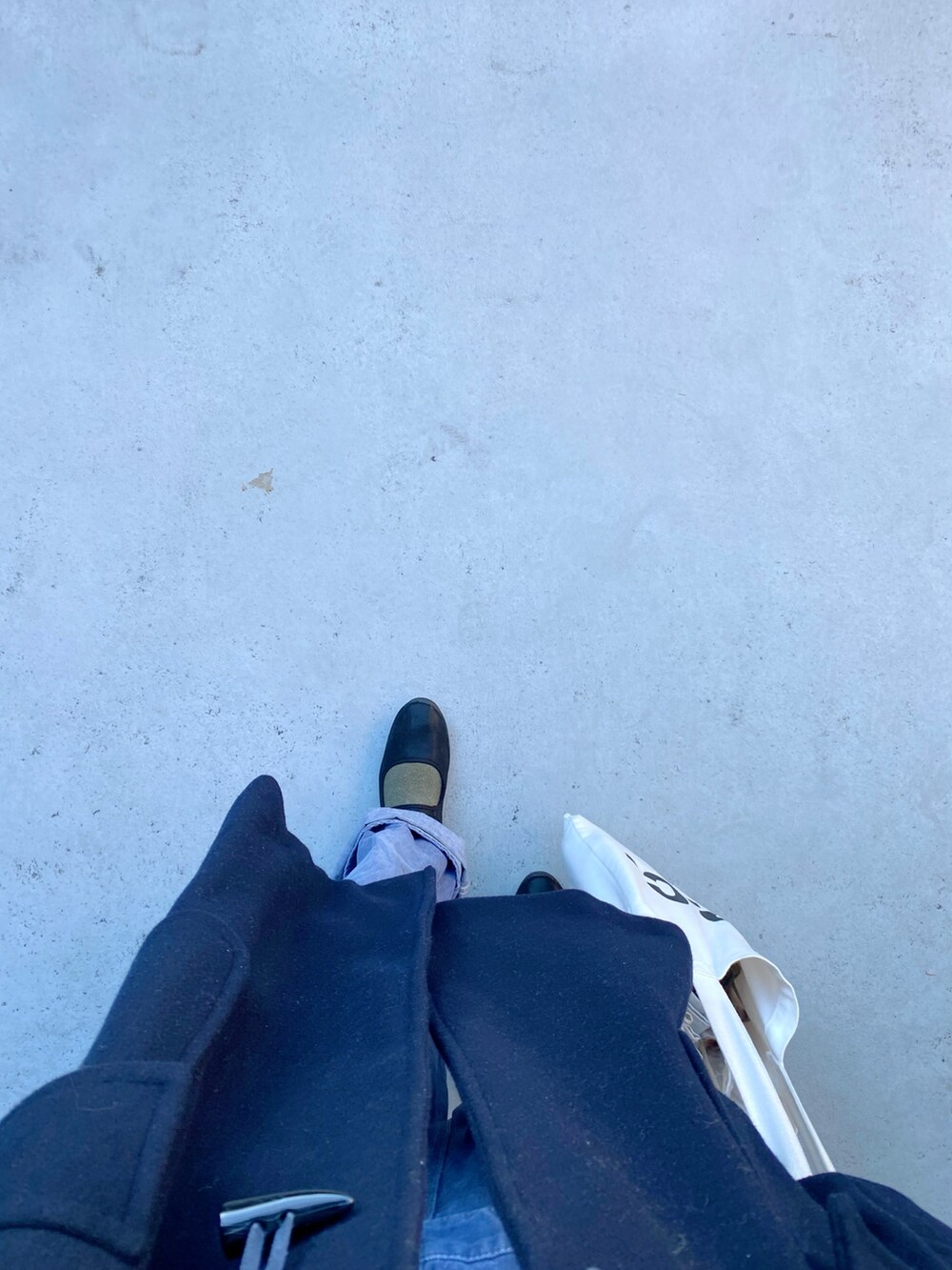 ブラック系のシューズ、ブルー系のオールインワン・サロペット、ホワイト系のバッグを着用したレディースの秋コーディネートの3枚目の写真