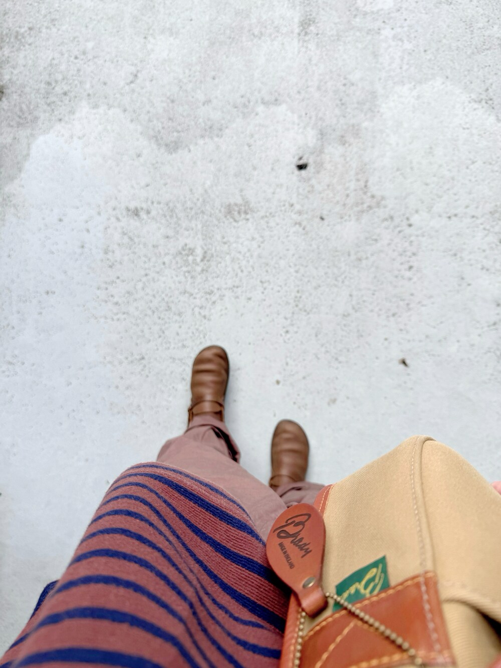 ブラウン系のシューズ、ブラウン系のパンツ、ベージュ系のショルダーバッグを着用したレディースの秋コーディネートの2枚目の写真