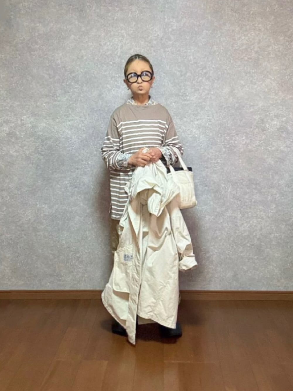 ブラック系のシューズ、ホワイト系のバッグ、ベージュ系のパンツを着用したレディースの春コーディネートの2枚目の写真