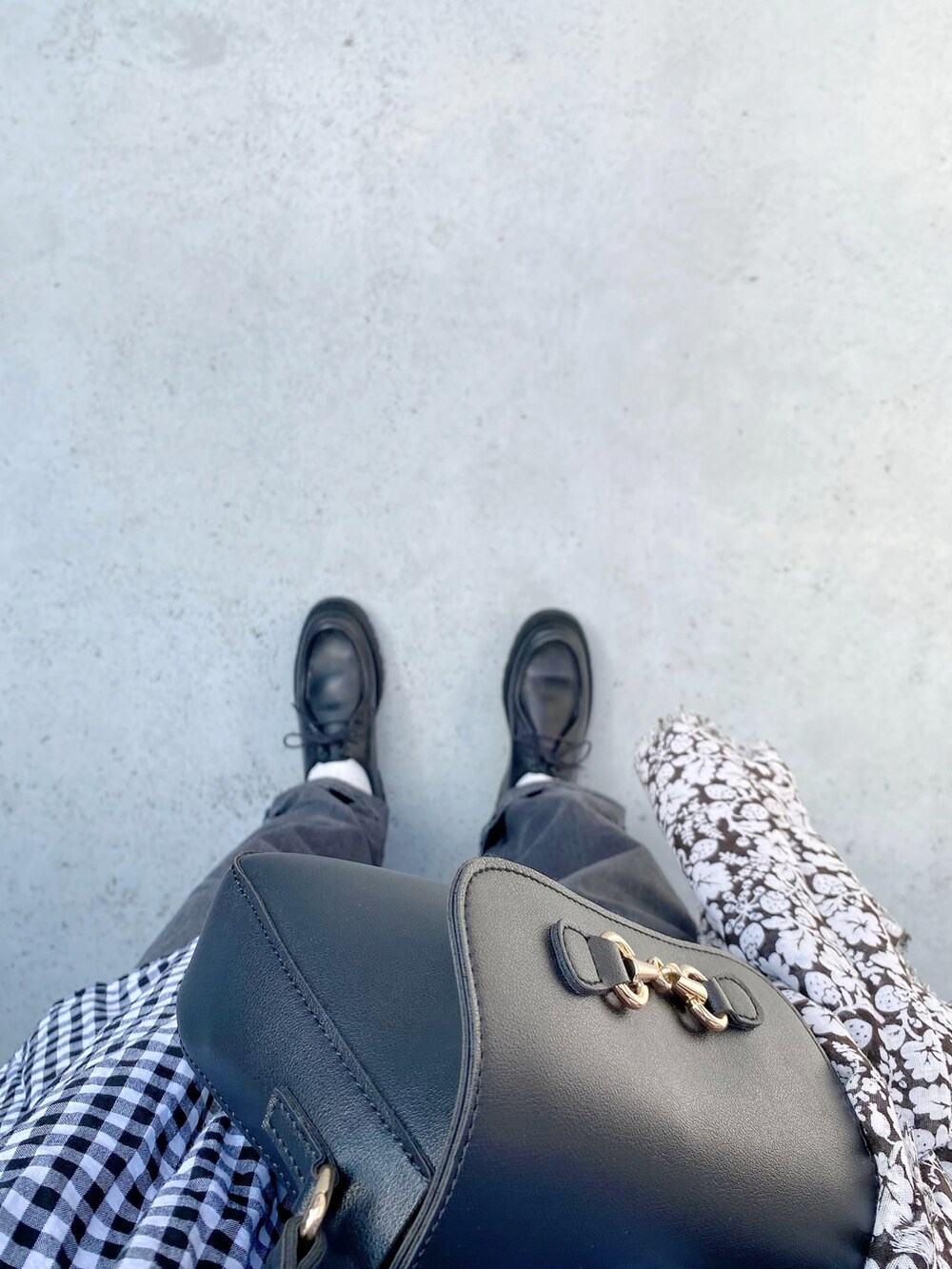 ブラック系のモカシン/デッキシューズ、ブラック系のパンツ、ブラック系のバッグを着用したレディースの秋コーディネートの2枚目の写真