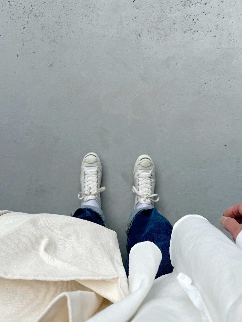 ホワイト系のスニーカー、ブルー系のパンツ、ホワイト系のバッグを着用したレディースの春コーディネートの2枚目の写真