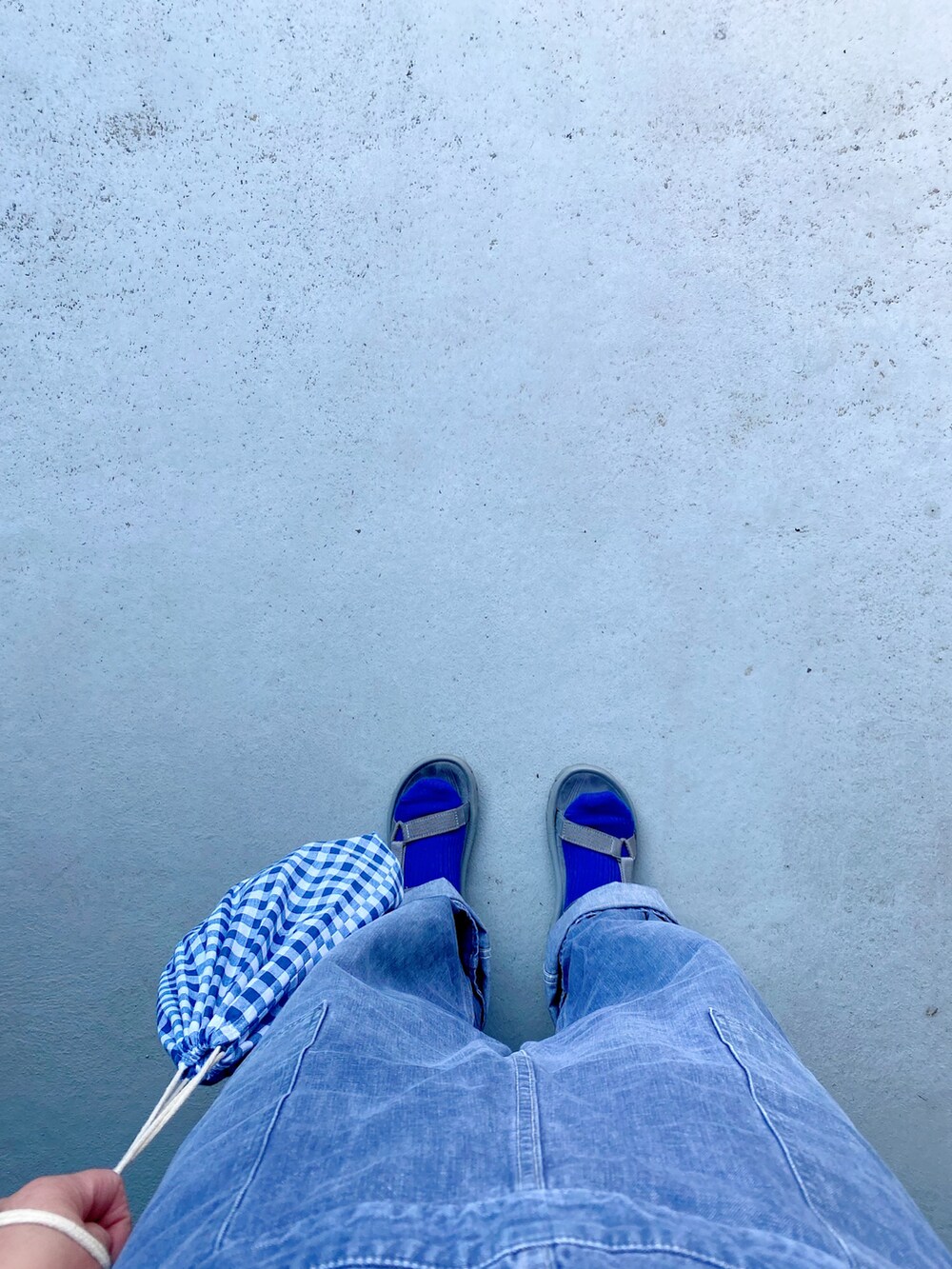 グレー系のシューズ、ブルー系のオールインワン・サロペット、ブルー系のバッグを着用したレディースの春コーディネートの3枚目の写真