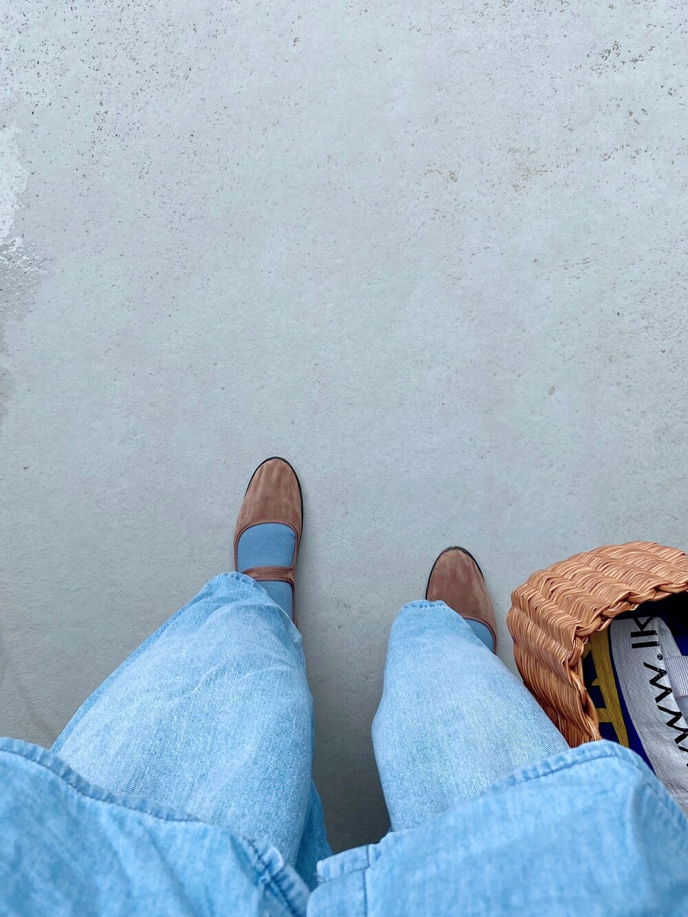 ブラウン系のシューズ、ブルー系のデニムパンツ、ブラウン系のバッグを着用したレディースの春コーディネートの2枚目の写真