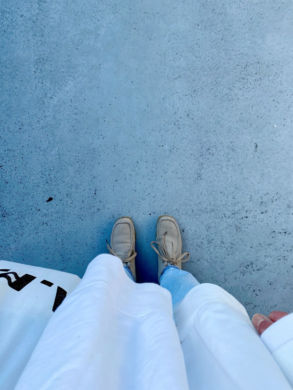 ベージュ系のシューズ、ホワイト系のバッグ、ブルー系のパンツを着用したレディースの春コーディネートの2枚目の写真