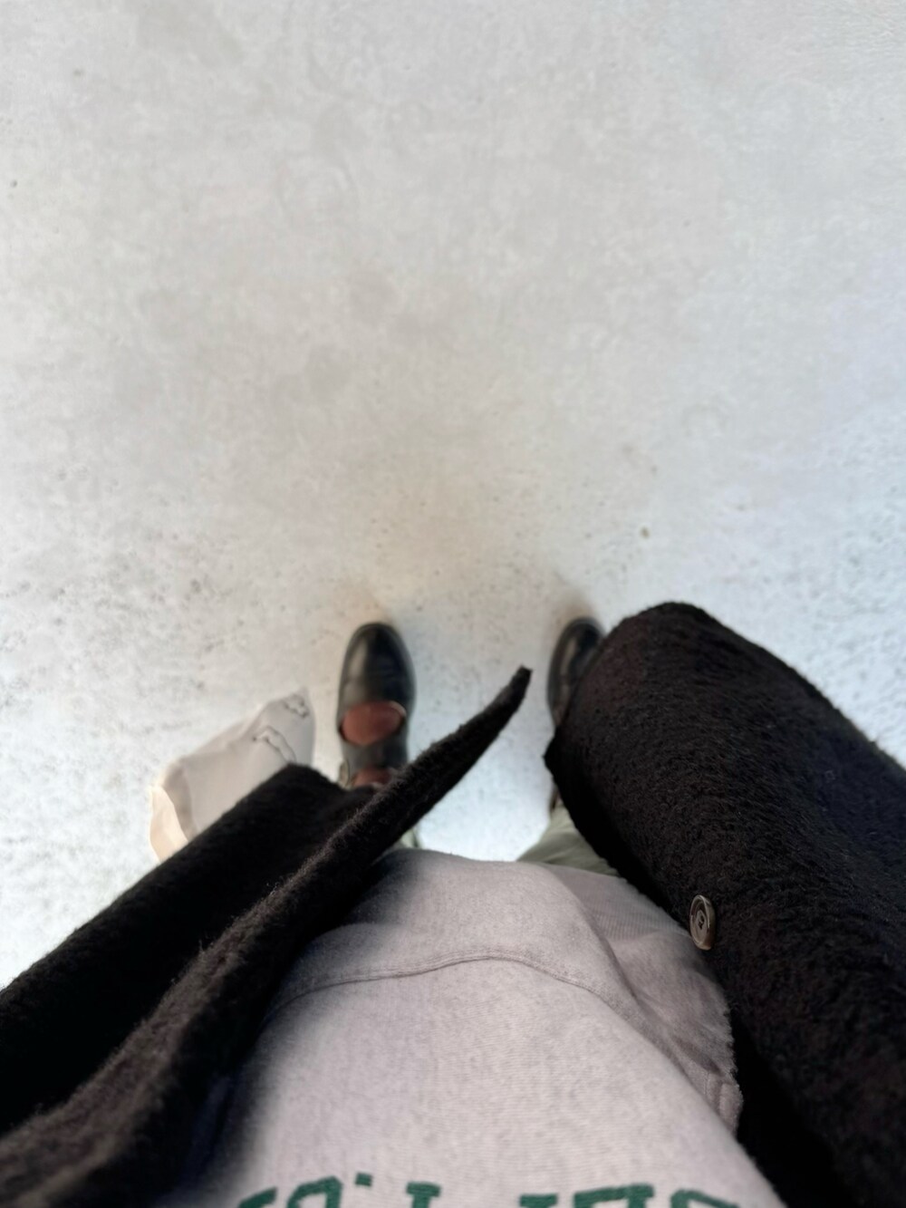 ブラック系のシューズ、ホワイト系のバッグ、グリーン系のパンツを着用したレディースの冬コーディネートの2枚目の写真